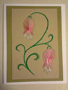 a card with pink flowers and green stems on it's side, in the shape of a number 2