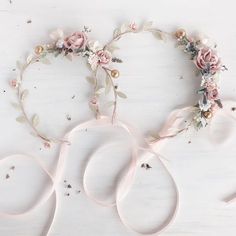 a pair of scissors and some flowers on top of a white table with pink ribbon