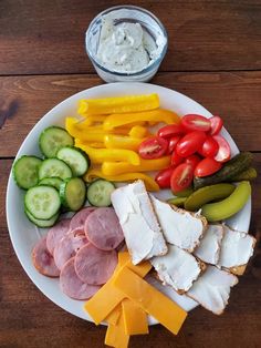 a white plate topped with meat, cheese and veggies