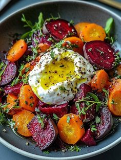 a bowl filled with beets, carrots and an egg on top of it