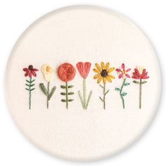 embroidered flowers are arranged on a white surface