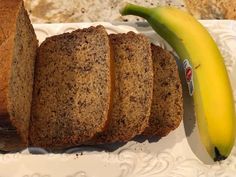 slices of banana bread on a plate next to a loaf of bread and a ripe banana