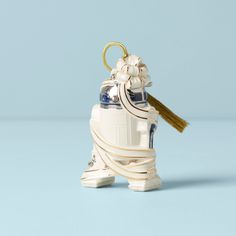 an ornament shaped like a star wars droid with a tassel hanging from it's side