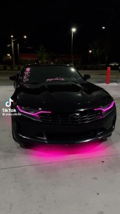 a black car with pink lights on it