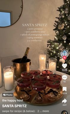 a christmas tree with candles and wine glasses on it in front of a poster advertising santa spritz