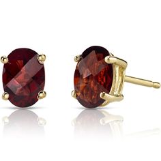 two pairs of earrings with red stones in gold plated setting on a white background