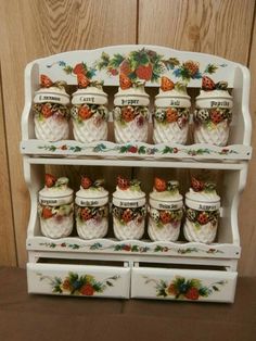 a white shelf with many jars on it