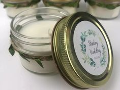 several small jars filled with candles sitting on top of a white table next to each other