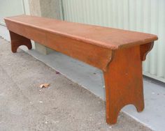 an old wooden bench sitting in front of a building