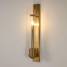 a light that is on the wall next to a white wall with a glass tube