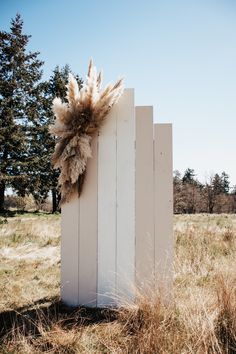 a tall white wooden structure with dried grass on it's front and back ends