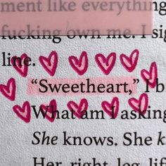 some pink hearts are on top of a piece of paper with the words, she knows she's here