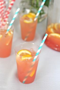 there are many glasses with drinks in them on the table and one has a blue striped straw