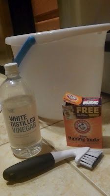 a bottle of alcohol, toothbrush and razor sitting on a tiled counter next to a container