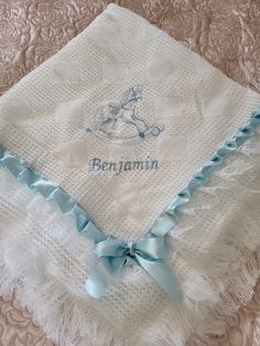 a personalized baby blanket with a blue ribbon on it and the name bernamin