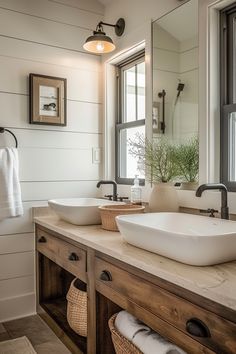 a bathroom with two sinks and a large mirror above it's countertop, along with towels hanging on the wall