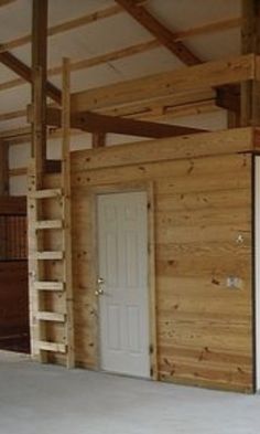 an empty room with wooden walls and stairs