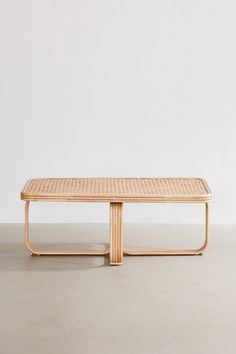 a wooden table sitting on top of a cement floor next to a white wall in an empty room