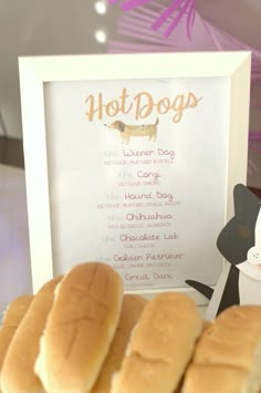 hot dogs with buns sitting in front of a sign