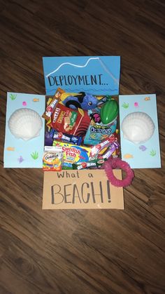 an assortment of candy and candies is displayed on the floor next to a sign that says deployment what a beach