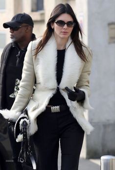 a woman walking down the street wearing black and white