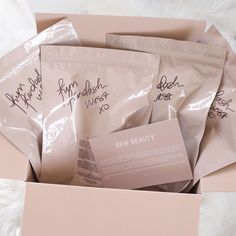 five packets of new beauty products in a pink box with writing on the front and back