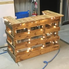 a pallet with some lights on it in the middle of a room and a blue bucket next to it