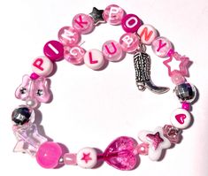 a pink and white bracelet with charms on it's sides, including a cowboy boot