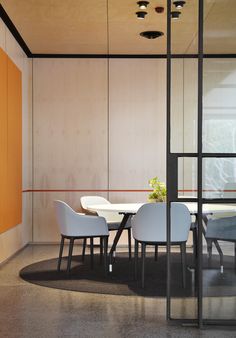 a dining room table with four chairs and a vase on the table in front of it