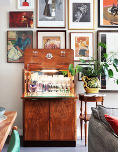 a room with pictures on the wall and an old fashioned cabinet in front of it