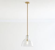 a clear glass pendant light hanging from a ceiling fixture in a white room with a wooden floor