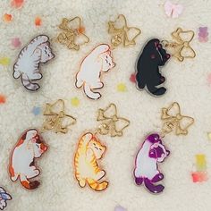 a group of different colored bears sitting on top of a white blanket next to confetti