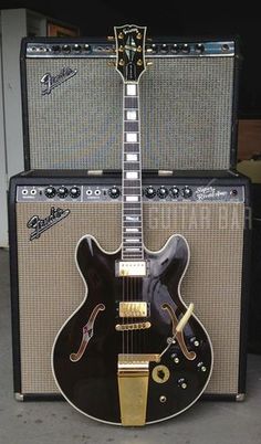 an electric guitar sitting next to two amps