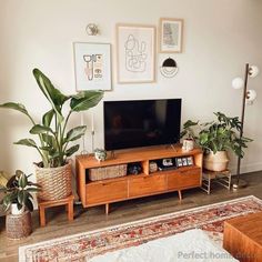 a flat screen tv sitting on top of a wooden entertainment center in a living room