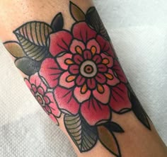 a close up of a person's foot with a flower tattoo design on it