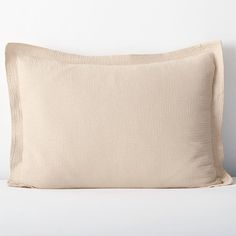 a white pillow sitting on top of a bed