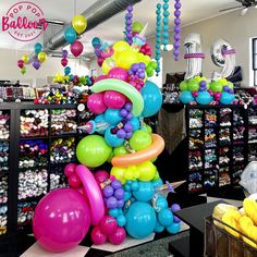 there are many balloons hanging from the ceiling in this store that is filled with items