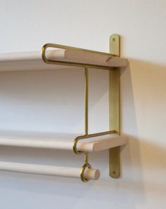 two white shelves with brass handles against a white wall