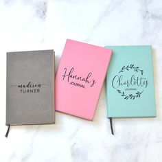 three personalized notebooks sitting on top of a marble counter with the words hannah turner journal written in cursive writing