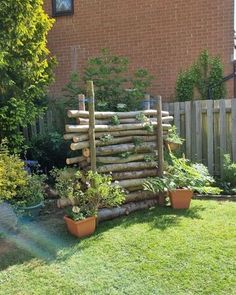 a wooden fence made out of logs and plants