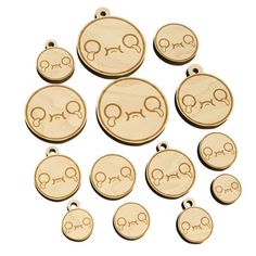 small wooden charms with faces on them in various shapes and sizes, all engraved into the shape