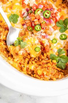 a white bowl filled with taco soup and topped with cilantro, jalapenos