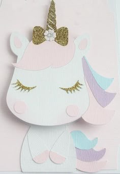 a card with a unicorn face and gold glitter on the top, in pastel colors