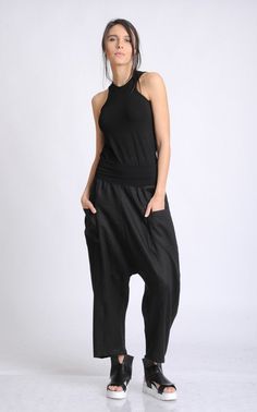 Black Minimalist Pants - METP0055 A pair of pants created with love and care especially for our customers so they can feel wonderful every time the put them on! Those casual trousers are great for every day wear due to the maxi and very comfortable fit. Thanks to the cotton based material belt part, the pants have elasticity around the waist which gives you even more comfort and ability to walk freely. The style is a loose and oversized one with a drop crotch part and wide legs. There are two po Baggy Black Harem Pants For Summer, Baggy Black Tapered Leg Harem Pants, Versatile Black Parachute Pants For Spring, Black Harem Bottoms For Spring, Black Baggy Harem Pants, Black Drop Crotch Bottoms For Summer, Black Harem Parachute Pants With Pockets, Black Relaxed Fit Harem Pants, Black Versatile Harem Pants