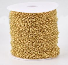 a spool of gold colored thread on a white background