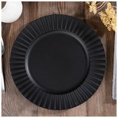 a black plate sitting on top of a wooden table