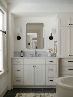 a white bathroom with two sinks and a bathtub