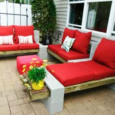 a red couch sitting on top of a brick patio