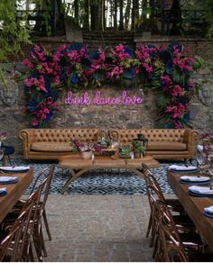 an outdoor seating area is decorated with pink flowers and greenery for a wedding reception