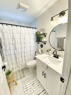 a bathroom with a toilet, sink and shower curtain